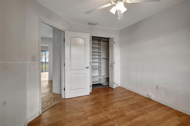 unfurnished bedroom with ceiling fan, a closet, a textured ceiling, and light hardwood / wood-style flooring