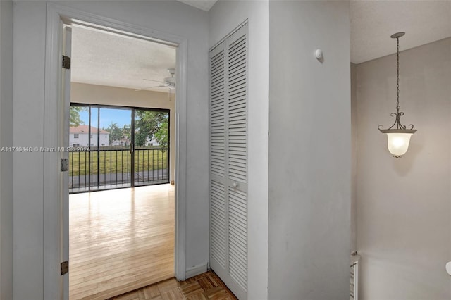 hall featuring parquet flooring and a textured ceiling