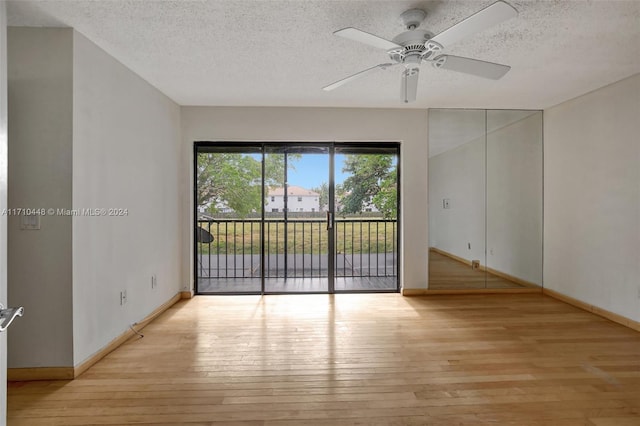 spare room with ceiling fan, a textured ceiling, and light wood-type flooring