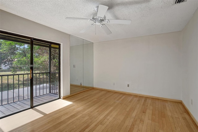 empty room featuring a textured ceiling, light hardwood / wood-style flooring, and ceiling fan