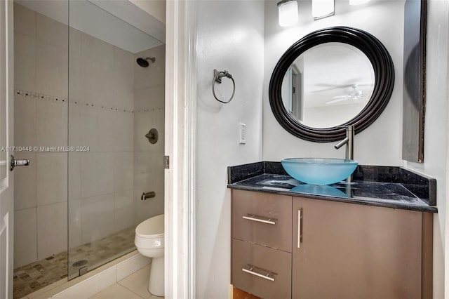 bathroom featuring an enclosed shower, vanity, ceiling fan, tile patterned flooring, and toilet