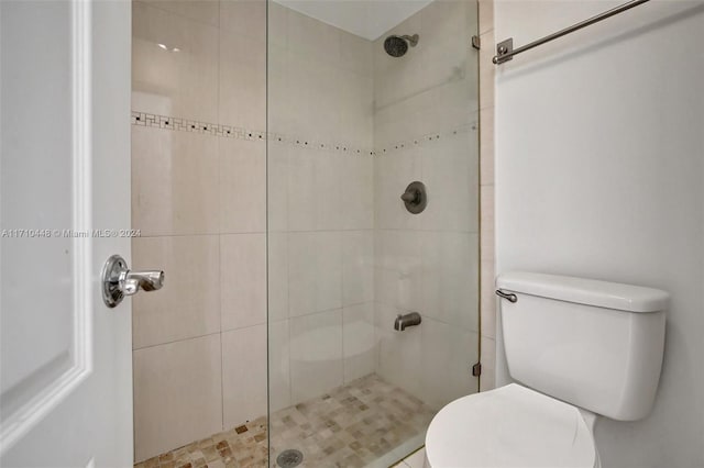 bathroom featuring a tile shower and toilet