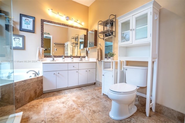 bathroom with a relaxing tiled tub, toilet, and vanity