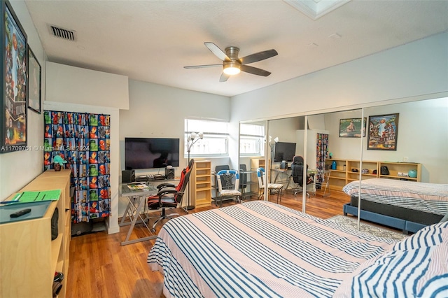 bedroom with hardwood / wood-style flooring, ceiling fan, and a closet