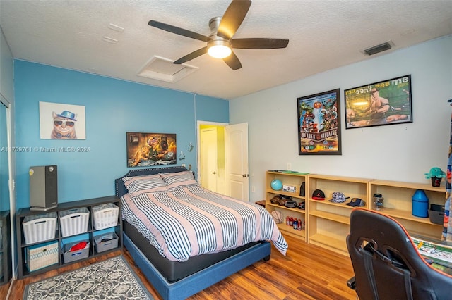 bedroom featuring hardwood / wood-style flooring, ceiling fan, and a textured ceiling