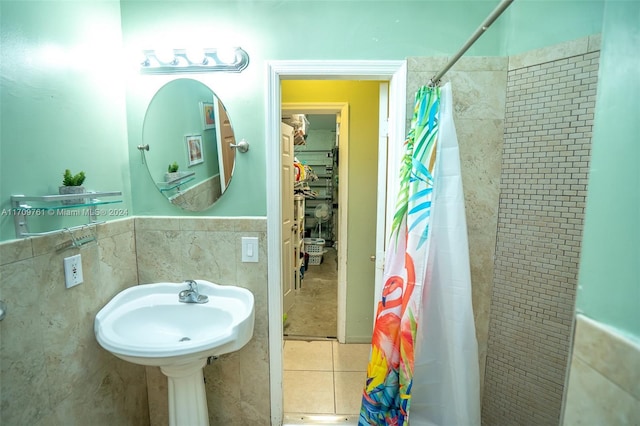 bathroom with sink, curtained shower, and tile walls