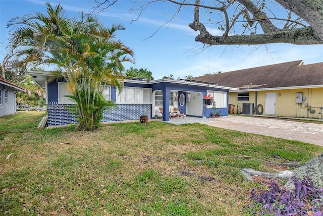 view of front of property featuring a front lawn and central AC unit