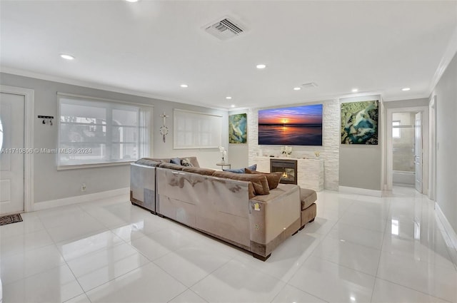 tiled living room with a tile fireplace and ornamental molding