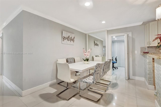 tiled dining area featuring crown molding