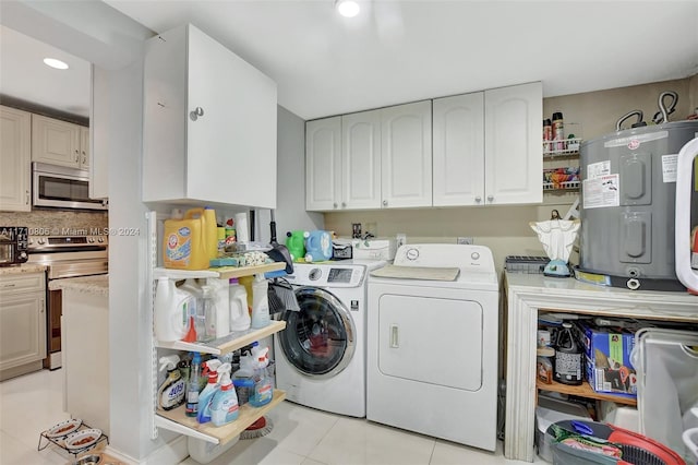 clothes washing area featuring washing machine and dryer, water heater, and light tile patterned floors