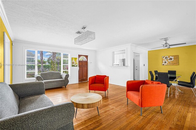 living room featuring a notable chandelier, crown molding, and hardwood / wood-style flooring