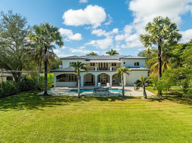 back of property with a lawn and a patio