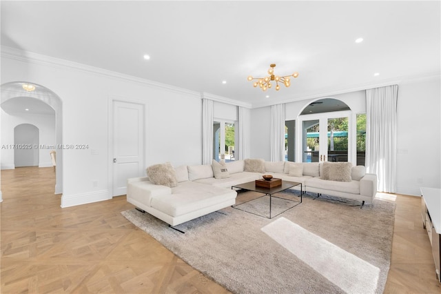 living room with light parquet flooring, crown molding, and a notable chandelier