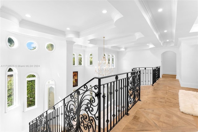 corridor featuring a chandelier, ornamental molding, light parquet flooring, and a healthy amount of sunlight