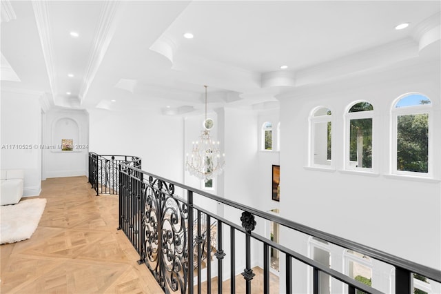 hall with plenty of natural light, light parquet floors, an inviting chandelier, and ornamental molding