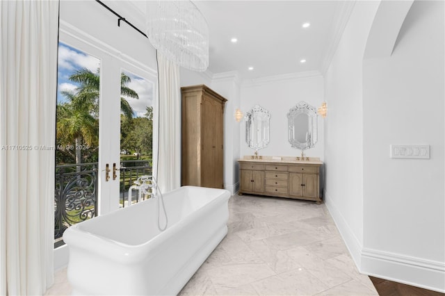 bathroom with ornamental molding, vanity, a tub to relax in, and a healthy amount of sunlight