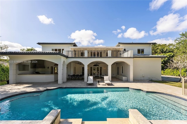 back of house with ceiling fan, a patio area, and a balcony