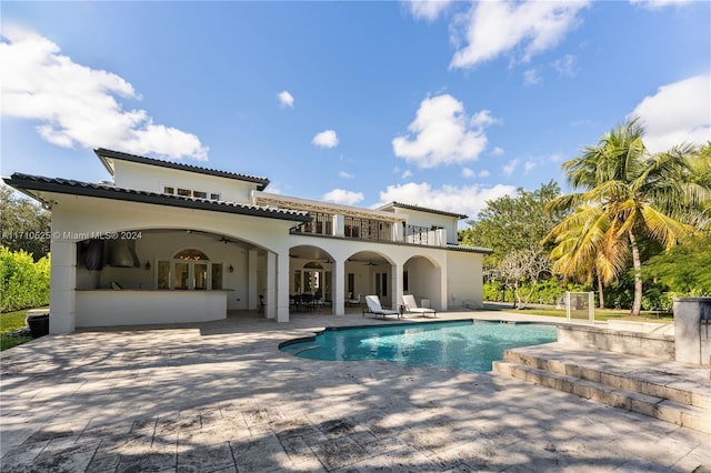 back of house with ceiling fan, a patio area, and a balcony