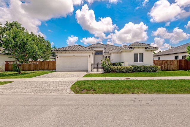 mediterranean / spanish-style home featuring a front lawn and a garage