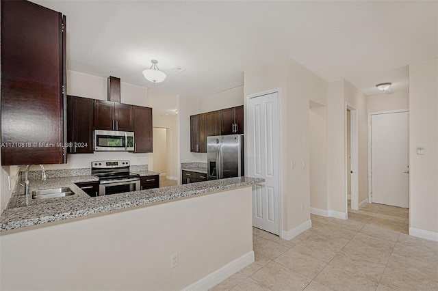 kitchen featuring sink, stainless steel appliances, light stone counters, kitchen peninsula, and dark brown cabinets