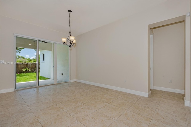 tiled spare room with a notable chandelier