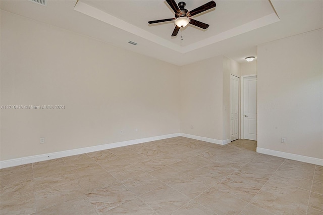 unfurnished room with a tray ceiling and ceiling fan