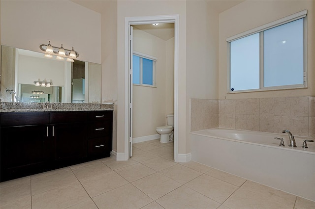 bathroom featuring tile patterned floors, a bathing tub, vanity, and toilet