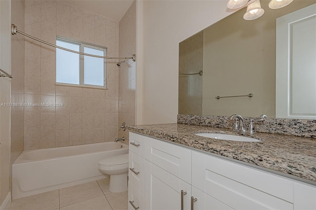 full bathroom with tile patterned flooring, vanity, tiled shower / bath combo, and toilet