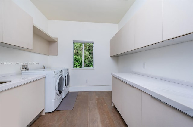 washroom with independent washer and dryer, cabinets, and light wood-type flooring