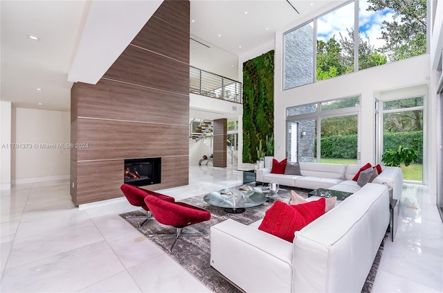 living room featuring a large fireplace and a high ceiling