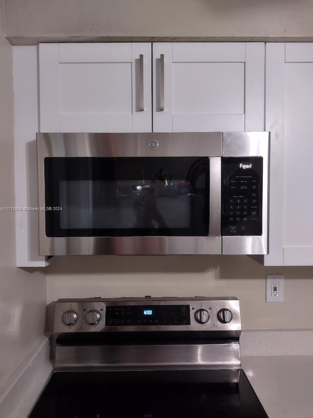 details with white cabinetry and appliances with stainless steel finishes