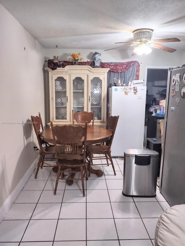 dining space featuring tile patterned flooring, a textured ceiling, and ceiling fan