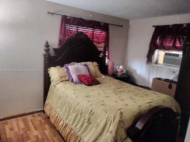 bedroom featuring hardwood / wood-style floors and cooling unit