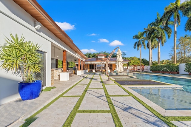 view of pool with pool water feature and a patio