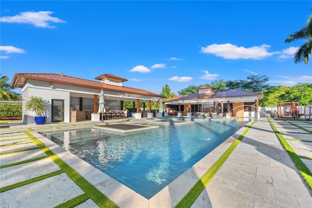 view of pool with a patio and an outdoor bar