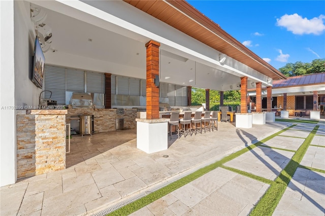 view of patio with exterior kitchen and an outdoor bar