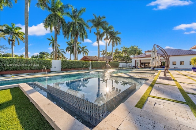 view of pool with pool water feature, a patio area, and an in ground hot tub