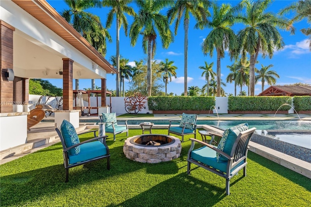 view of patio / terrace featuring pool water feature and an outdoor fire pit