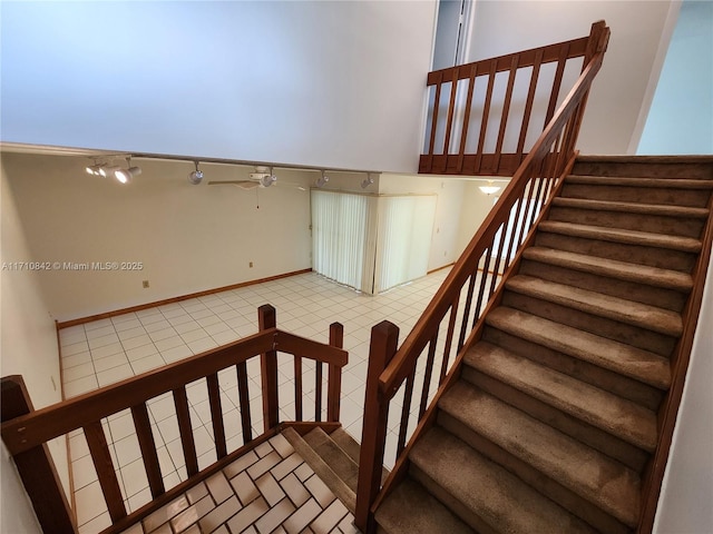 stairs featuring ceiling fan