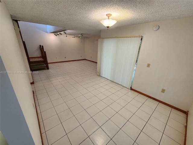 empty room with ceiling fan and a textured ceiling