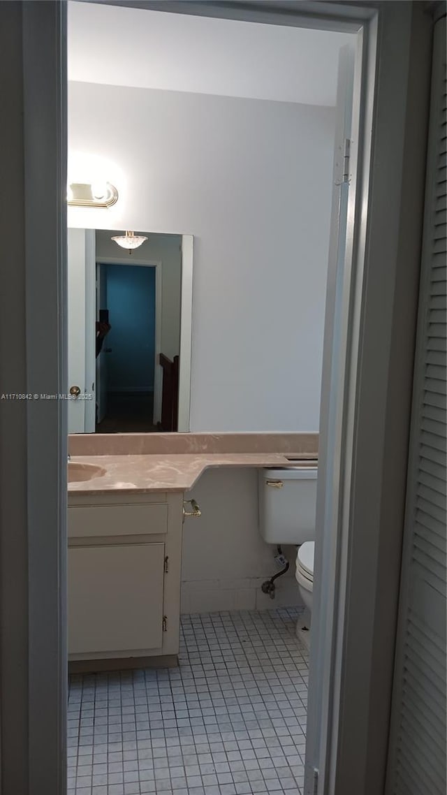 bathroom featuring tile patterned flooring, vanity, and toilet