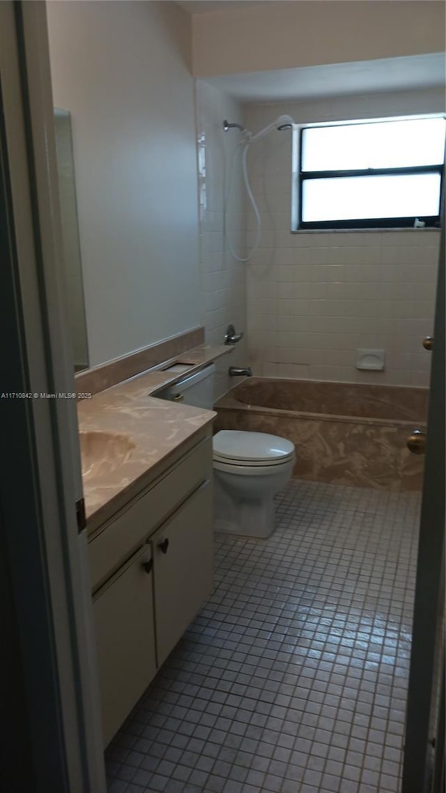 full bathroom with tile patterned floors, tiled shower / bath combo, toilet, and vanity