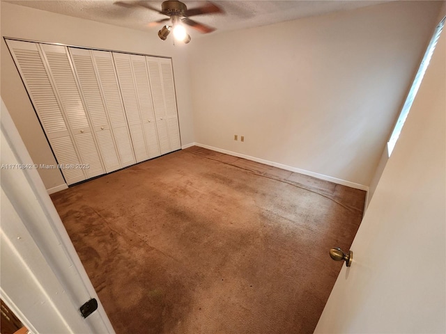 unfurnished bedroom featuring ceiling fan, carpet floors, a textured ceiling, and a closet