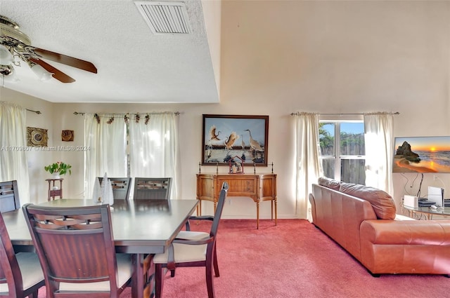 carpeted dining room with a textured ceiling and ceiling fan