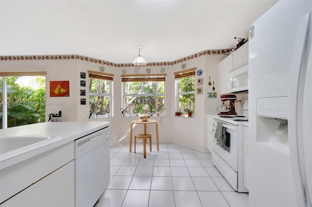 kitchen with light tile patterned floors, white cabinets, a healthy amount of sunlight, and white appliances