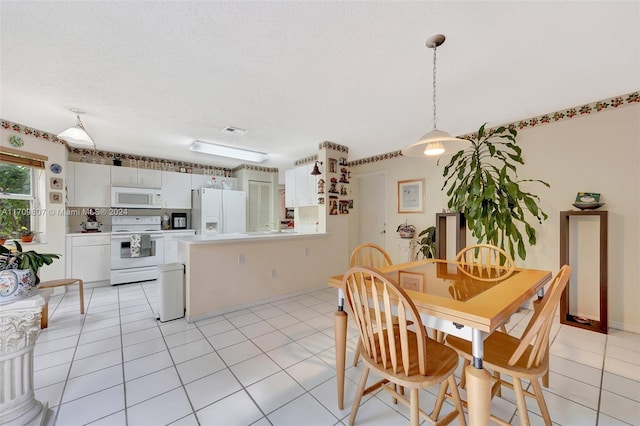 dining space featuring light tile patterned floors and a textured ceiling