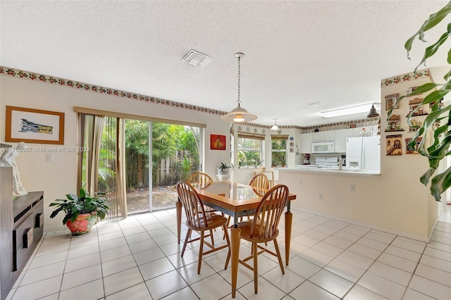 tiled dining space featuring a textured ceiling