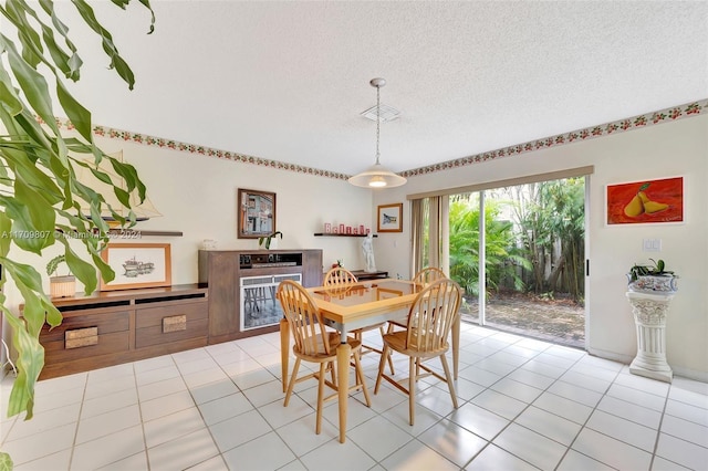 dining space featuring a textured ceiling and light tile patterned flooring