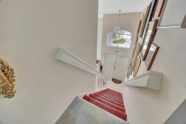 tiled entryway featuring a towering ceiling and a textured ceiling