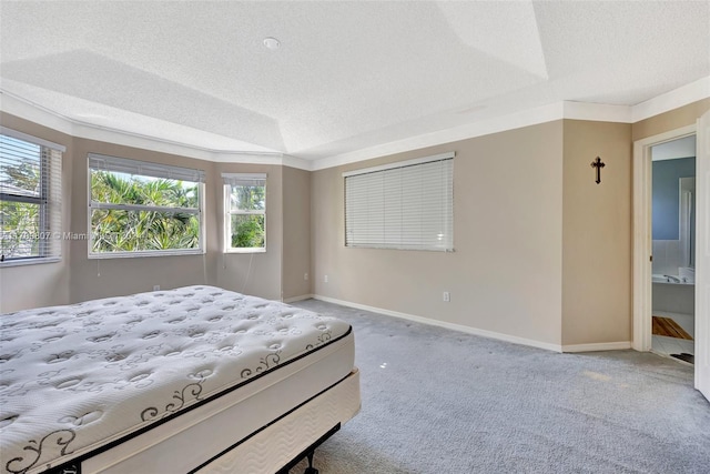 bedroom featuring carpet flooring, ensuite bath, crown molding, and a textured ceiling